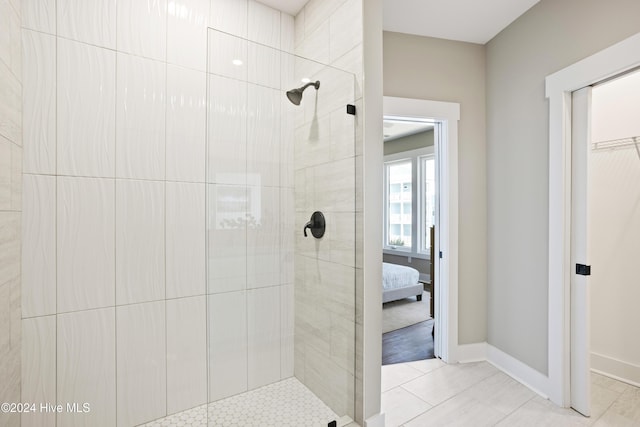 ensuite bathroom featuring ensuite bath, baseboards, and tiled shower