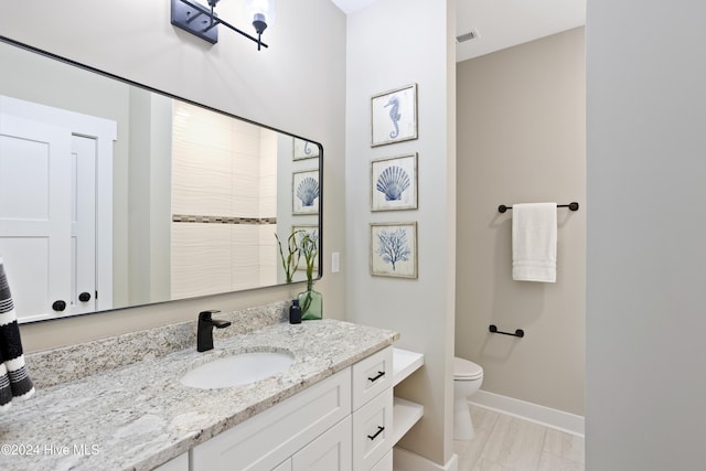 full bath featuring visible vents, baseboards, vanity, and toilet