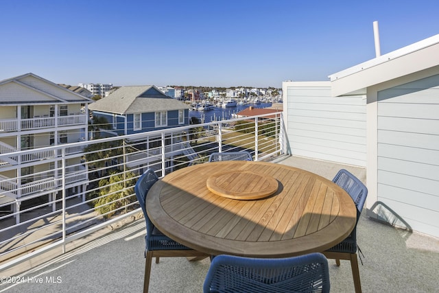 balcony featuring a water view and outdoor dining space