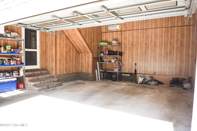 garage with wood walls and a garage door opener