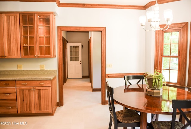 dining space featuring light floors, baseboards, crown molding, and a chandelier