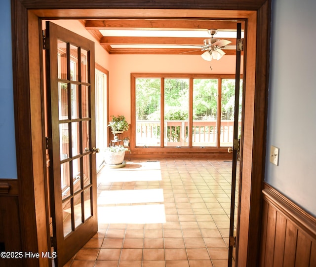 doorway to outside featuring wainscoting, a ceiling fan, french doors, and beam ceiling
