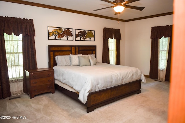 bedroom with ceiling fan, ornamental molding, and light carpet
