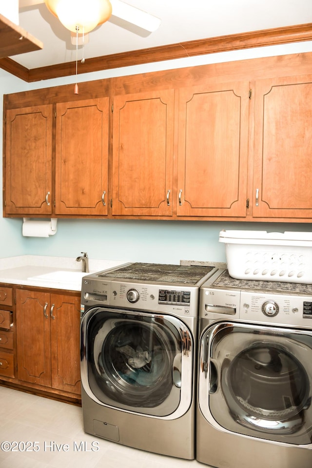 laundry area with ornamental molding, cabinet space, a sink, and independent washer and dryer
