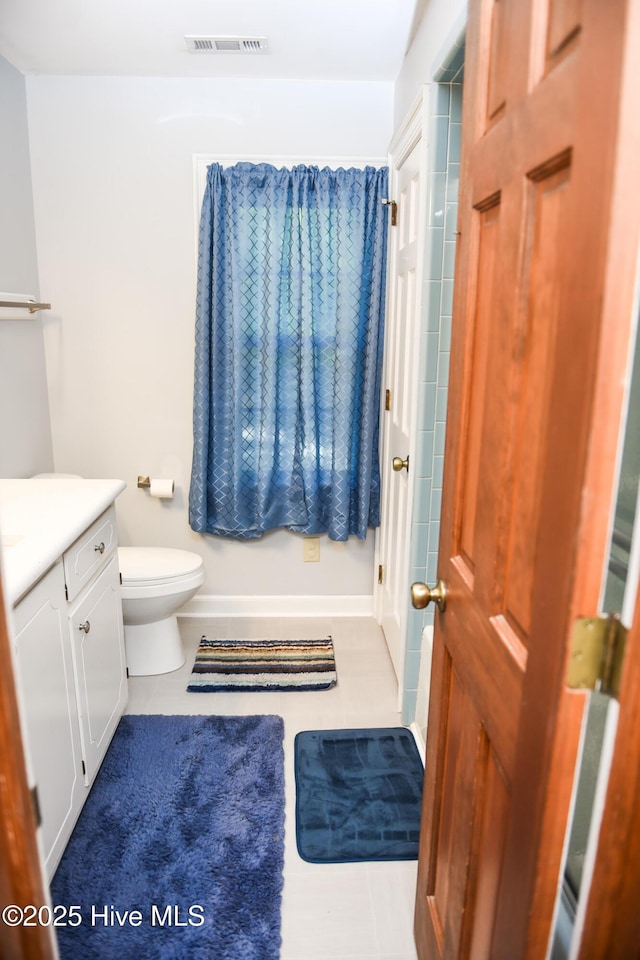 bathroom featuring tile patterned floors, visible vents, toilet, vanity, and baseboards