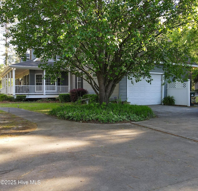 view of front of house with concrete driveway, a porch, and a garage