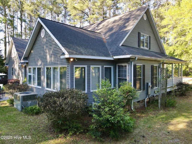 rear view of property with central air condition unit and a shingled roof