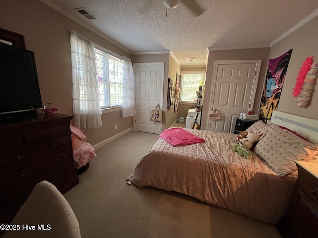 bedroom featuring a ceiling fan, crown molding, carpet floors, baseboards, and visible vents