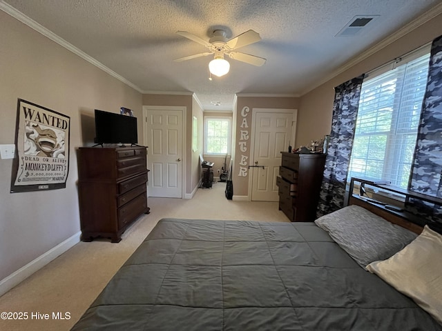 carpeted bedroom with a textured ceiling, ceiling fan, baseboards, ornamental molding, and visible vents