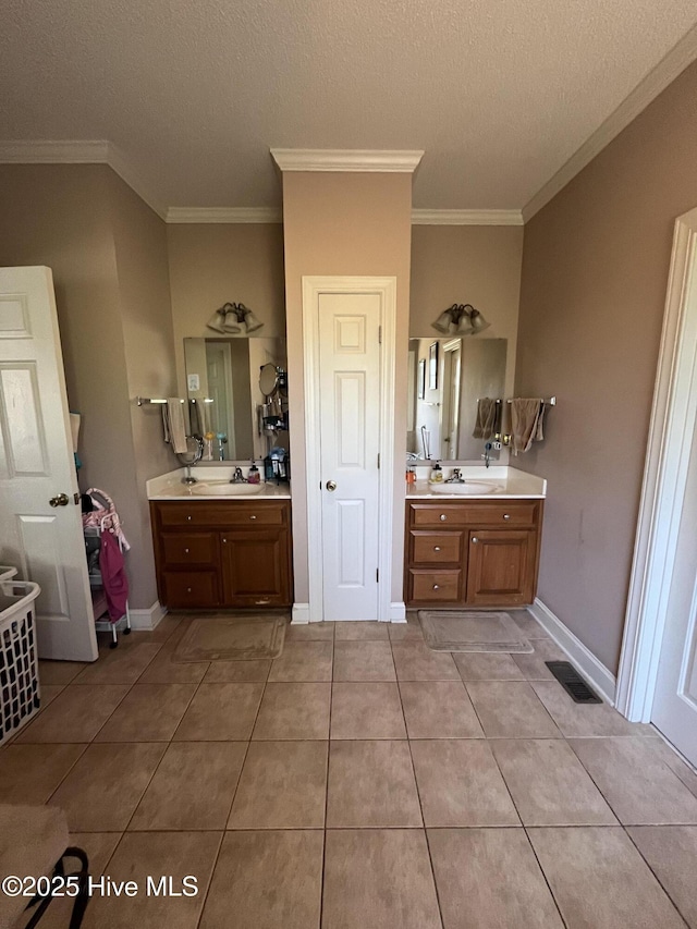 bathroom featuring ornamental molding, tile patterned floors, a sink, and visible vents