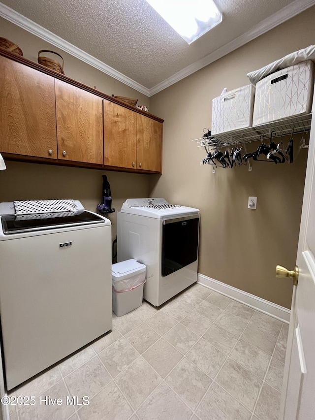 washroom with washer and clothes dryer, a textured ceiling, baseboards, cabinet space, and ornamental molding