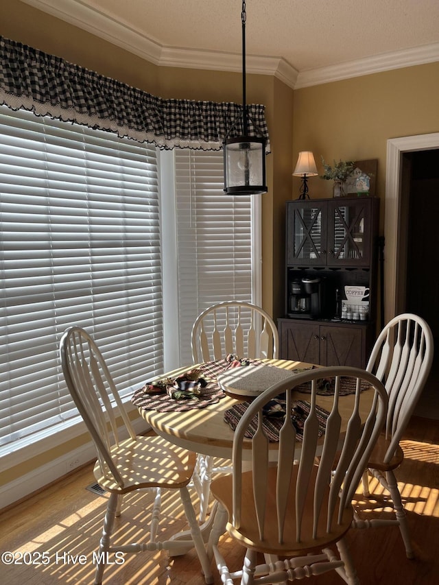 dining room featuring crown molding and wood finished floors