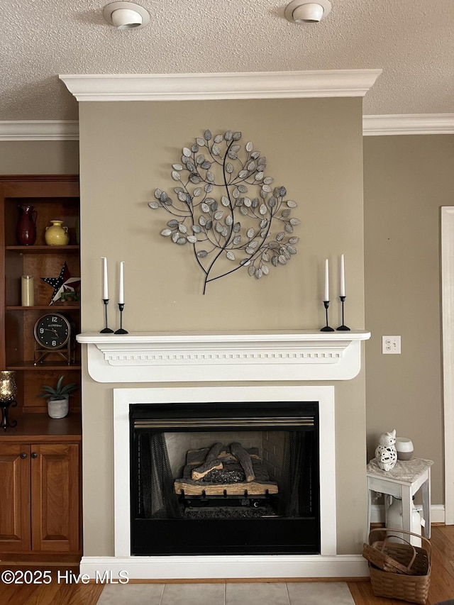 room details with a fireplace, wood finished floors, a textured ceiling, and crown molding