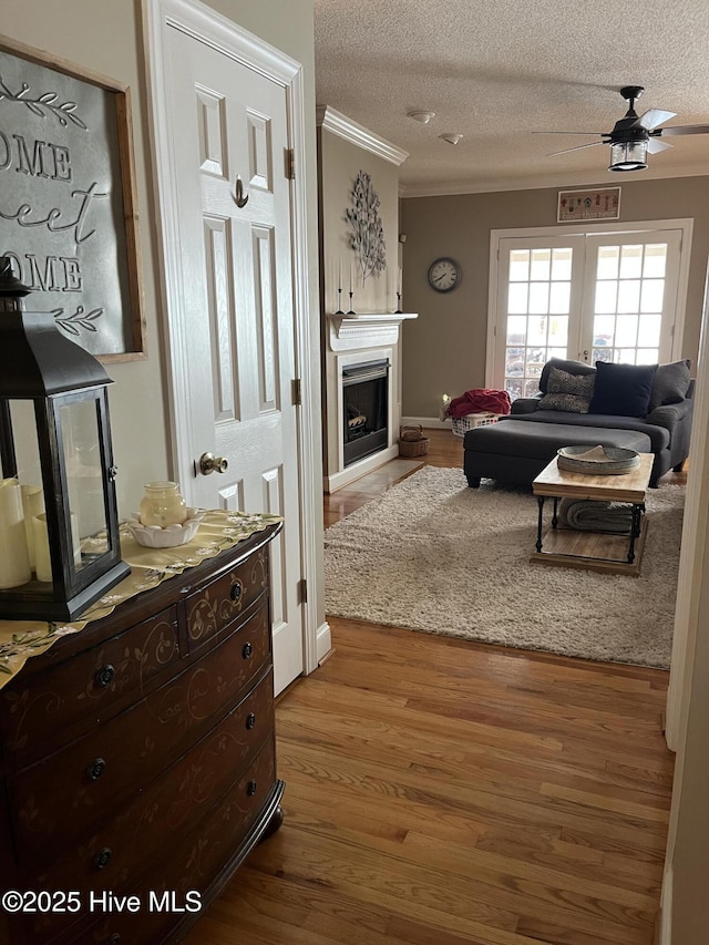 hall featuring ornamental molding, wood finished floors, and a textured ceiling