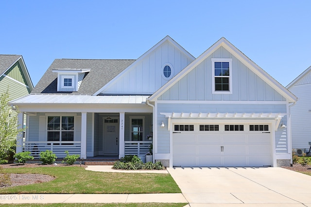 3347 Island Lakes Dr, Oak Island, NC 28461 - view of front of home featuring covered porch, concrete driveway, an attached garage, a shingled roof, and board and batten siding