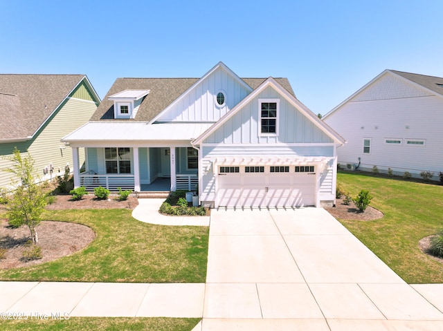 3347 Island Lakes Dr, Oak Island, NC 28461 - view of front facade featuring roof with shingles, driveway, covered porch, board and batten siding, and a front yard