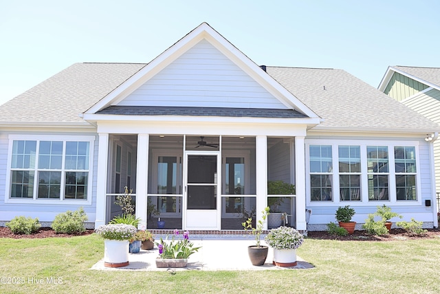 3347 Island Lakes Dr, Oak Island, NC 28461 - rear view of house featuring a lawn, a shingled roof, and a sunroom