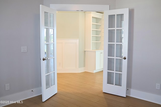3347 Island Lakes Dr, Oak Island, NC 28461 - interior space with wainscoting, french doors, and wood finished floors