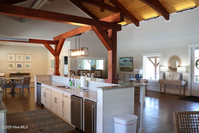 3347 Island Lakes Dr, Oak Island, NC 28461 - kitchen featuring a sink, beamed ceiling, hanging light fixtures, open floor plan, and white cabinetry