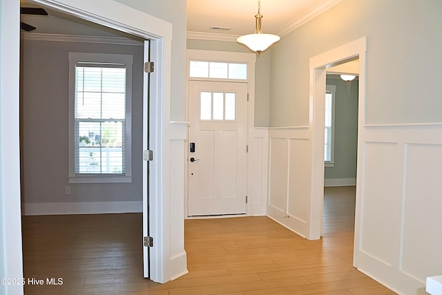 3347 Island Lakes Dr, Oak Island, NC 28461 - entrance foyer featuring wainscoting, a decorative wall, crown molding, and light wood-style flooring