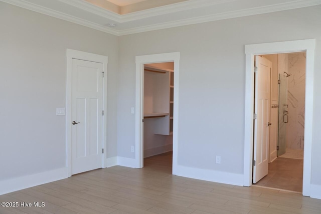 3347 Island Lakes Dr, Oak Island, NC 28461 - unfurnished bedroom with light wood finished floors, baseboards, a spacious closet, a closet, and ornamental molding