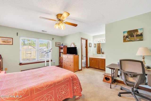 3421 Bethel Rd, Wilmington, NC 28409 - bedroom featuring light carpet, connected bathroom, a sink, a textured ceiling, and ceiling fan