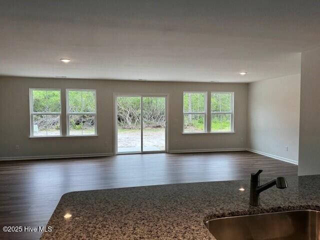 spare room featuring a sink, dark wood-type flooring, baseboards, and recessed lighting