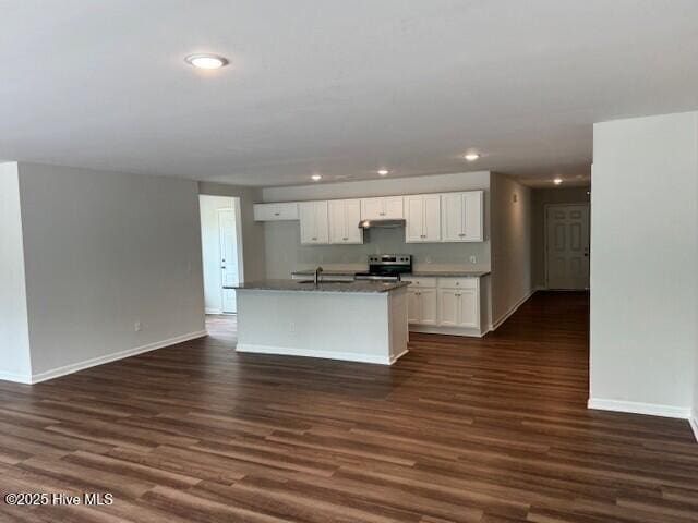 kitchen with stainless steel range with electric cooktop, baseboards, dark wood-type flooring, white cabinetry, and under cabinet range hood