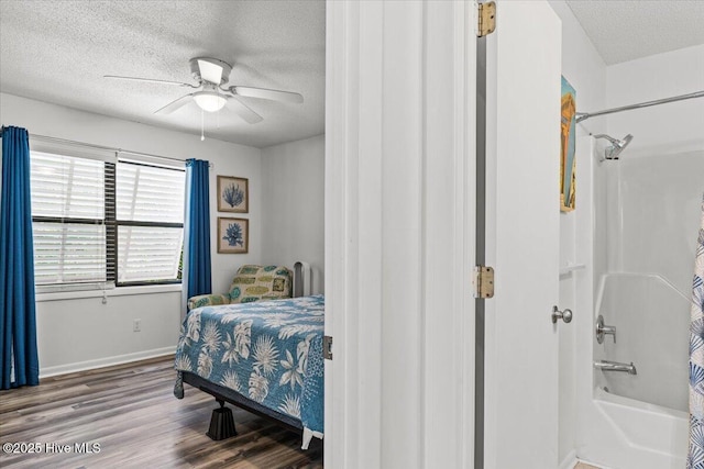 7501 E Oak Island Dr, Oak Island, NC 28465 - bedroom with a textured ceiling, wood finished floors, ceiling fan, and baseboards