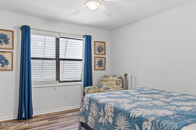 7501 E Oak Island Dr, Oak Island, NC 28465 - bedroom with a ceiling fan, multiple windows, wood finished floors, and baseboards