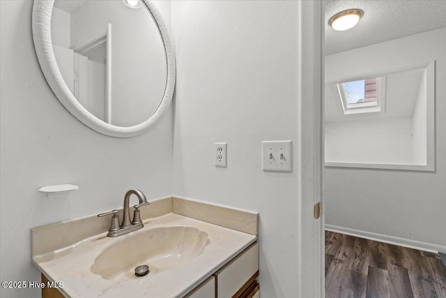 7501 E Oak Island Dr, Oak Island, NC 28465 - bathroom with a skylight, wood finished floors, and vanity