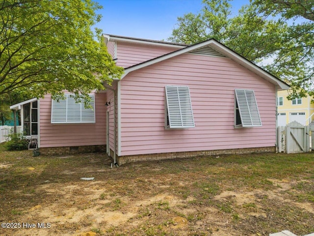 7501 E Oak Island Dr, Oak Island, NC 28465 - view of side of property with fence and a sunroom