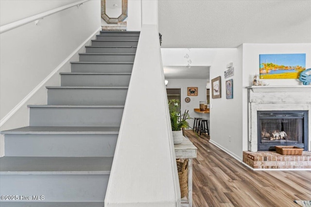 7501 E Oak Island Dr, Oak Island, NC 28465 - stairs featuring wood finished floors, a fireplace with raised hearth, and baseboards