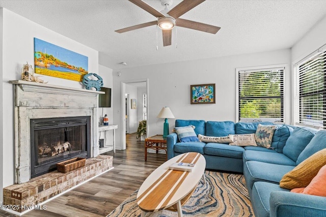 7501 E Oak Island Dr, Oak Island, NC 28465 - living room featuring a fireplace, a textured ceiling, wood finished floors, and ceiling fan