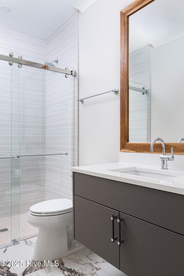 1800 Canal Dr Unit 401, Carolina Beach, NC 28428 - bathroom featuring marble look tile flooring, a shower stall, vanity, and toilet
