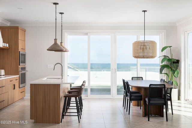 1800 Canal Dr Unit 401, Carolina Beach, NC 28428 - kitchen with a sink, modern cabinets, ornamental molding, light countertops, and a breakfast bar