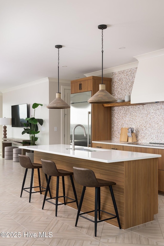 1800 Canal Dr Unit 401, Carolina Beach, NC 28428 - kitchen with stainless steel built in refrigerator, ornamental molding, light countertops, a large island with sink, and a sink
