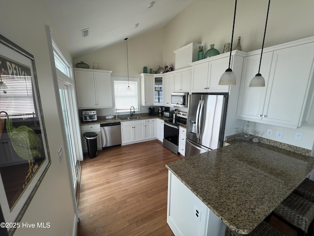 1113 Ocean Dr, Emerald Isle, NC 28594 - kitchen featuring stainless steel appliances, a peninsula, a sink, white cabinets, and dark stone counters