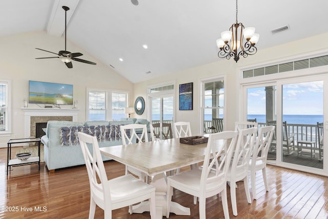 1113 Ocean Dr, Emerald Isle, NC 28594 - dining space featuring beam ceiling, high vaulted ceiling, ceiling fan with notable chandelier, wood finished floors, and visible vents