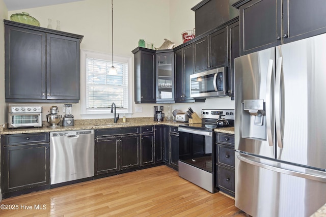 1113 Ocean Dr, Emerald Isle, NC 28594 - kitchen with decorative light fixtures, light wood-type flooring, a sink, light stone counters, and stainless steel appliances