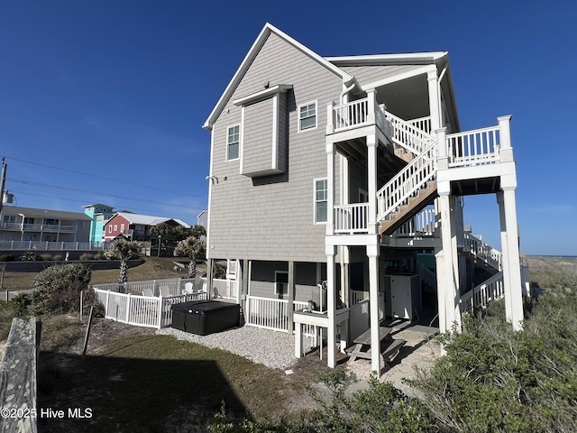 1113 Ocean Dr, Emerald Isle, NC 28594 - rear view of property featuring stairway, a hot tub, fence, and a wooden deck