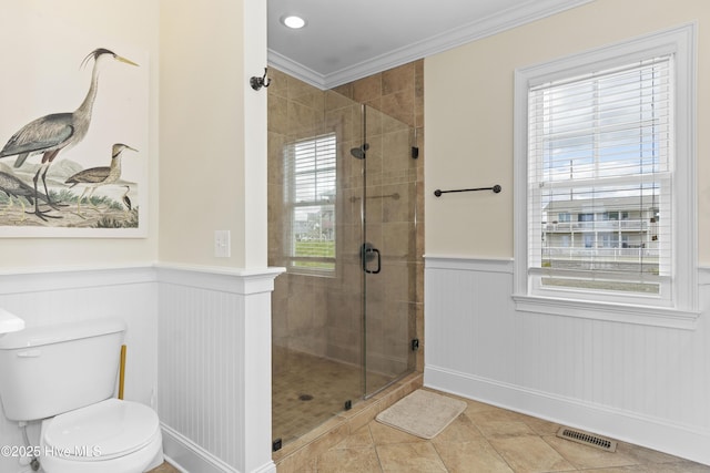 1113 Ocean Dr, Emerald Isle, NC 28594 - bathroom featuring visible vents, tile patterned flooring, a stall shower, a wainscoted wall, and ornamental molding