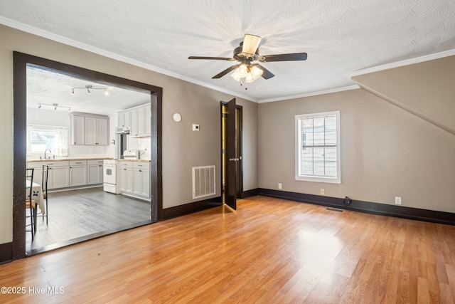 802 2nd St, Elizabeth City, NC 27909 - unfurnished living room featuring a sink, light wood-type flooring, visible vents, ceiling fan, and baseboards