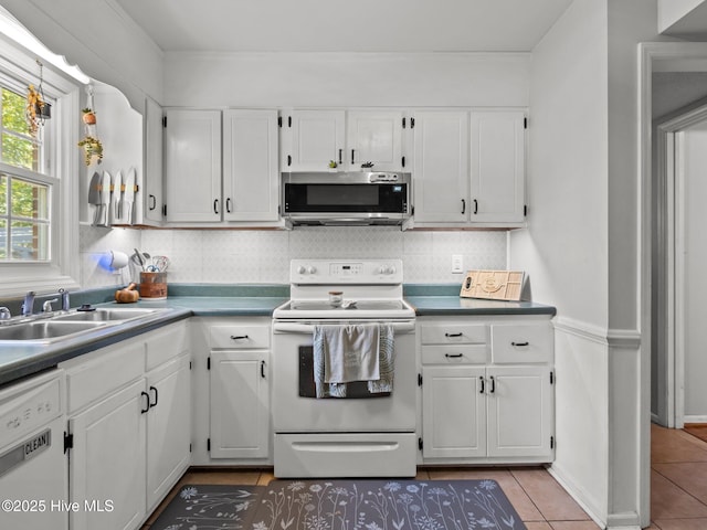 kitchen featuring white cabinets, decorative backsplash, a sink, and white appliances