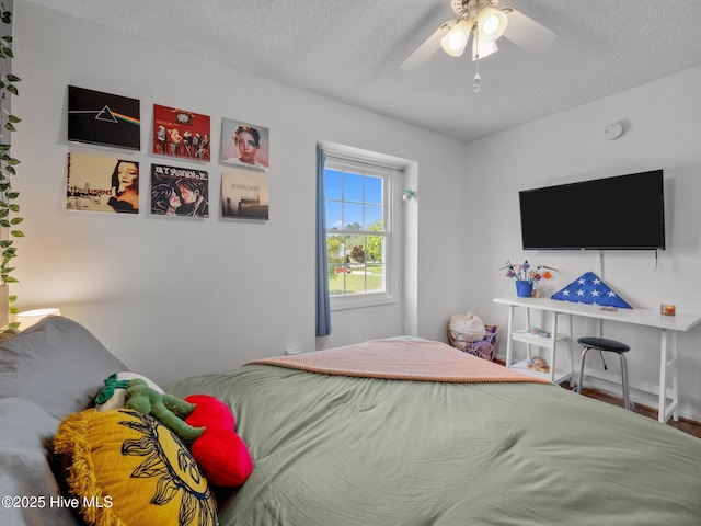bedroom with a ceiling fan and a textured ceiling