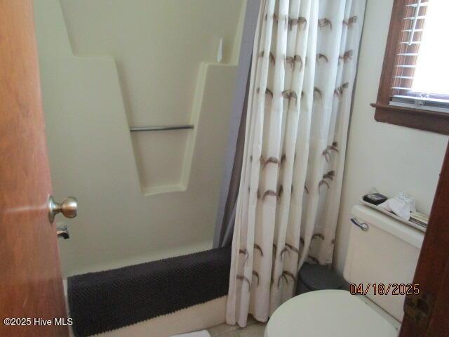 bathroom featuring toilet and a shower with shower curtain