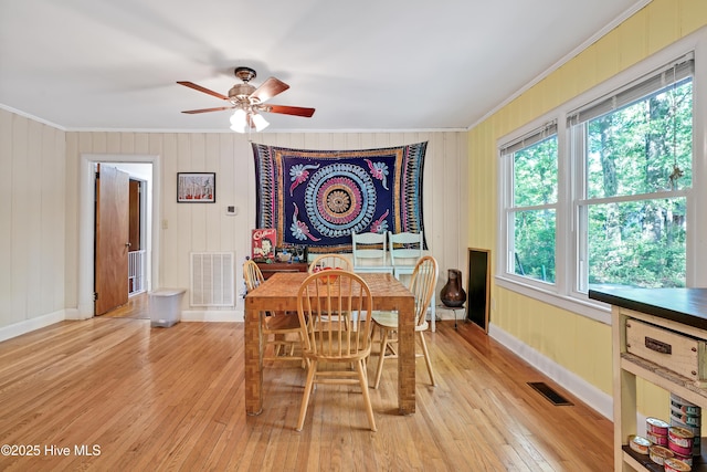 dining room with crown molding, visible vents, and light wood-type flooring