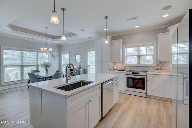 kitchen with light wood finished floors, stainless steel appliances, visible vents, and a sink