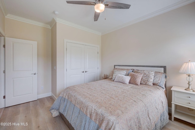 bedroom with wood finished floors, a closet, baseboards, and ornamental molding