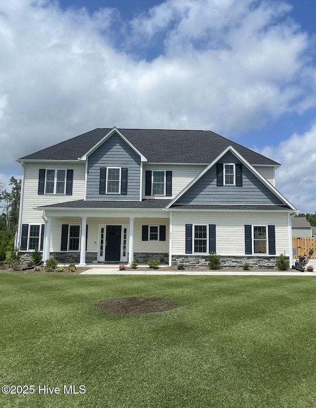 view of front of home featuring a porch, a front yard, and stone siding